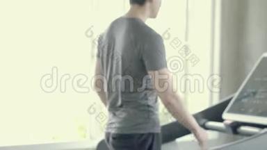 英俊的亚洲年轻人在健身房步行到跑步机，亚洲男人在跑步机上锻炼有氧运动以促进健康